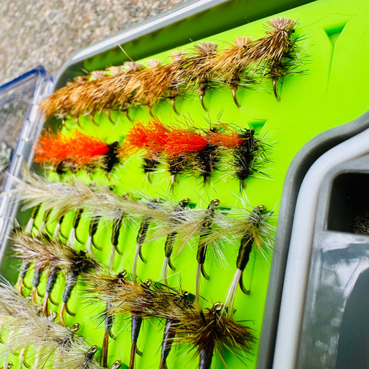 A detailed close-up of the dry fly selection in The Essentials Fly Box, including Elk Hair Caddis and Adams patterns.