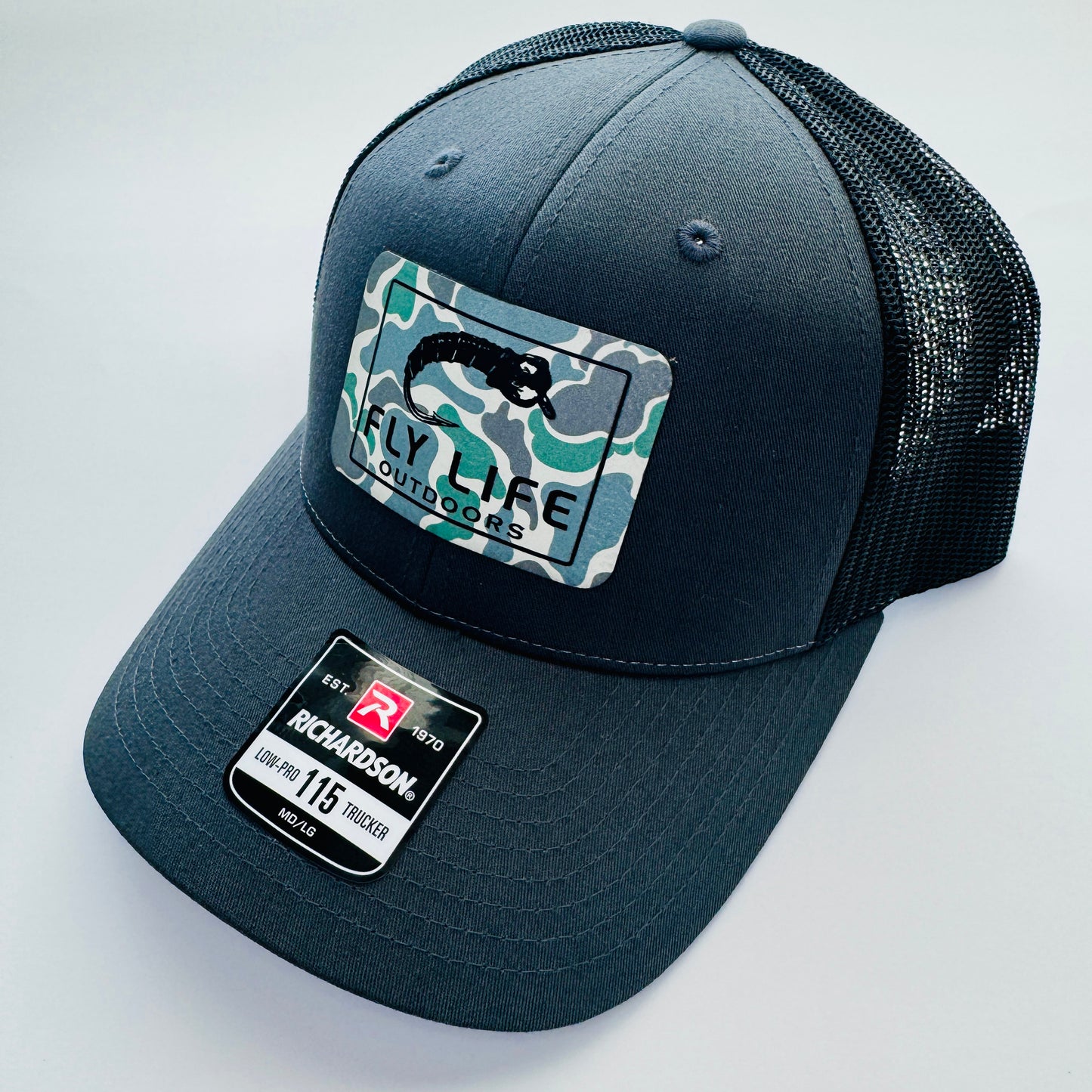 Right angle view of The FLO 115 Trucker in Charcoal with Black Midge/Low Tide Camo patch | Charcoal/Black