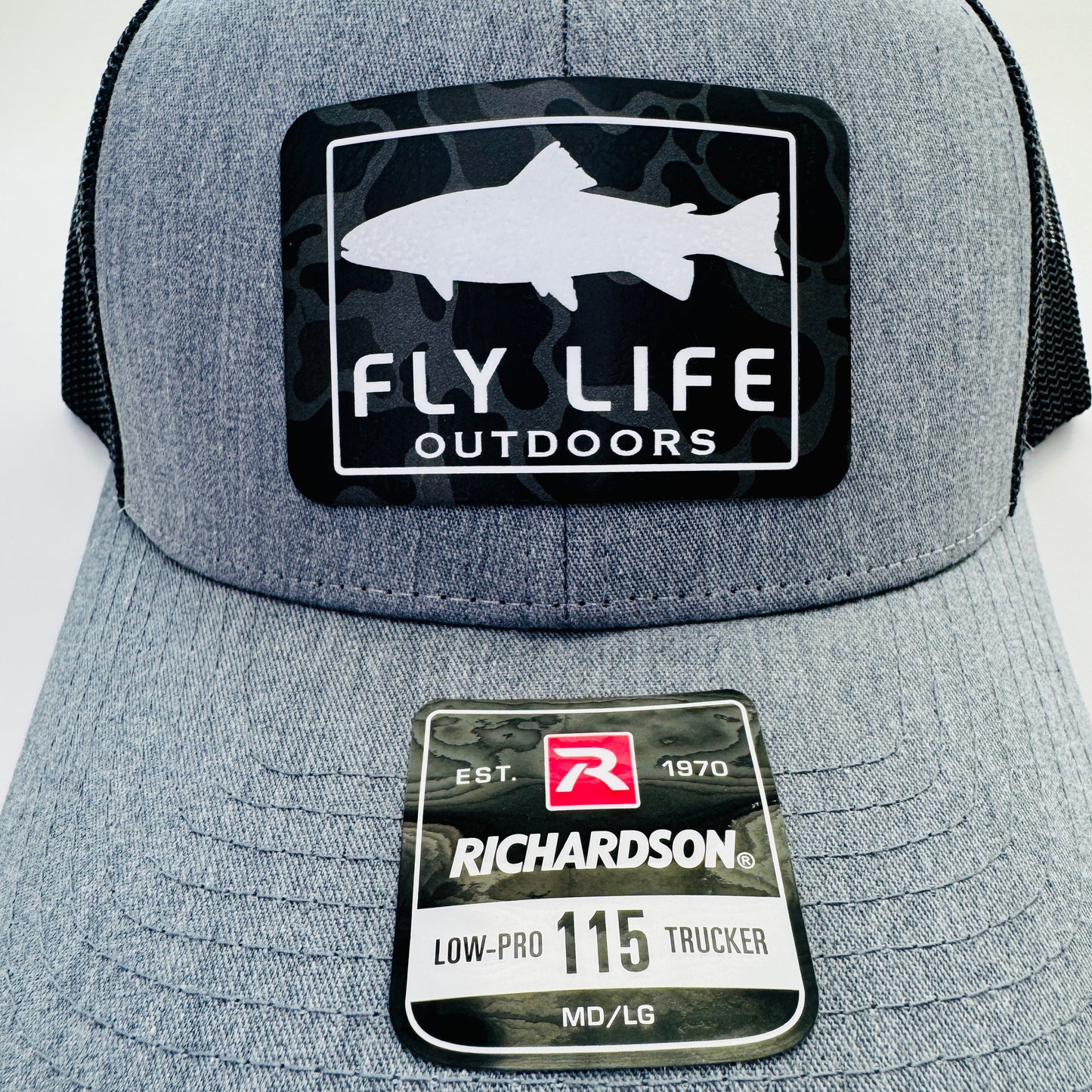 Close up view of The FLO 115 Trucker in Heather Grey with White Trout/Black Skies Camo patch | Heather Grey/Black