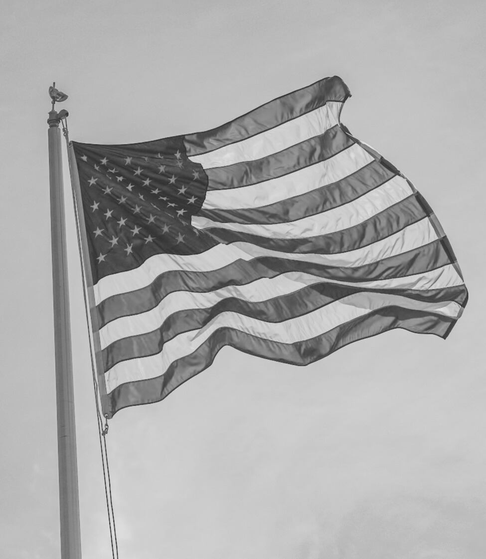 A powerful black and white image of the American flag, representing our veteran-owned roots | Fly Life Outdoors
