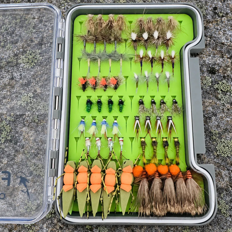 Open All-Water Arsenal fly box on lichen-covered rock with 70 trout flies, including green Morrish Hoppers and Hi-Viz Griffith’s Gnats.