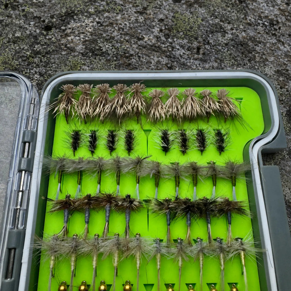 Close-up of Essentials fly box dry fly section showing hand-tied Elk Hair Caddis, Griffith's Gnat, Adams, and Blue Winged Olive patterns for WNC trout streams