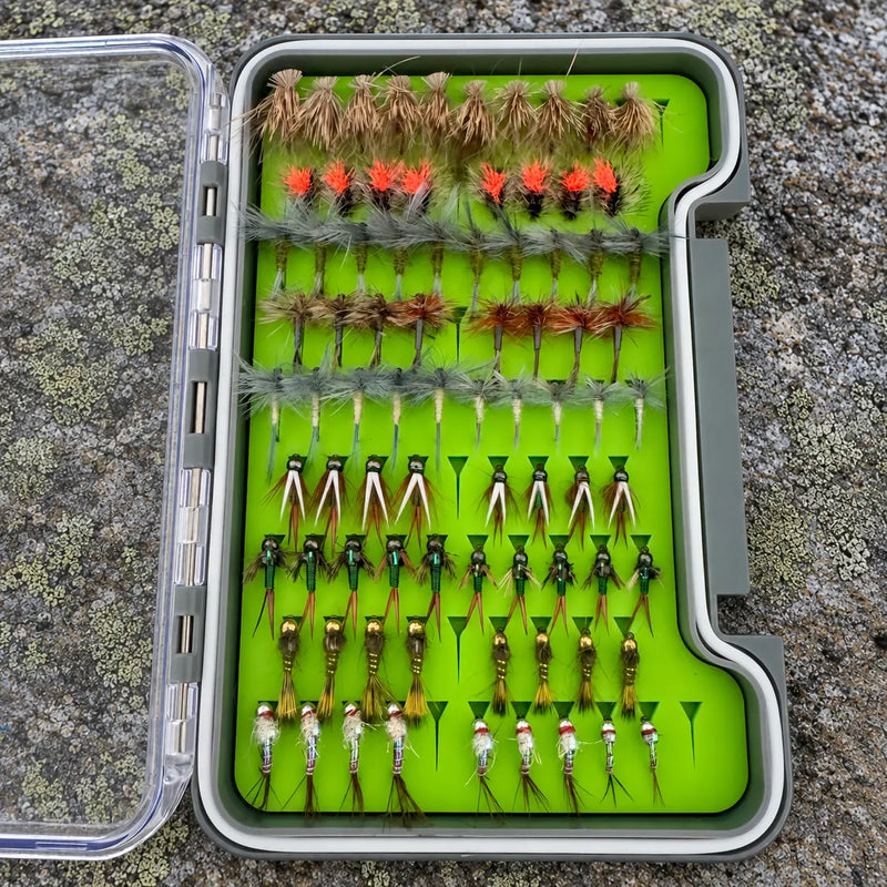 Essentials Loaded Fly Box on lichen-covered stone with the clear lid open to the left