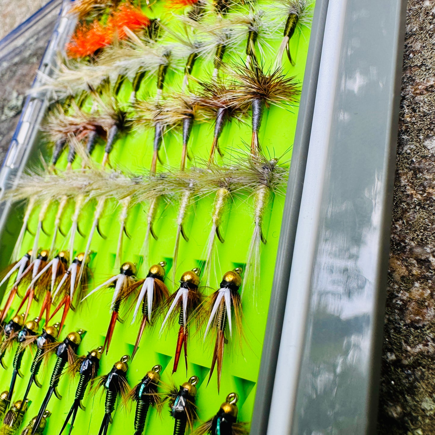 A detailed close-up of the dry fly selection in The Essentials Fly Box, including dry flies and nymphs.