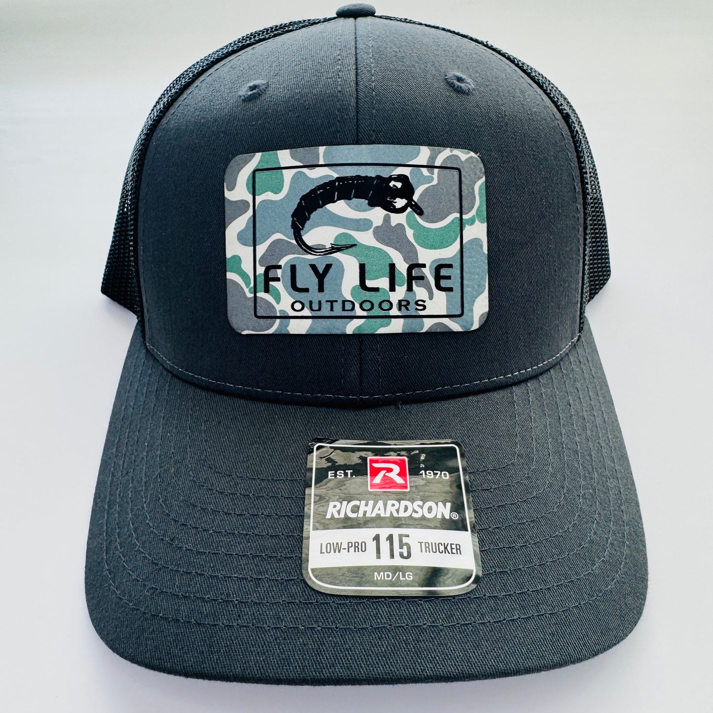 Front view of The FLO 115 Trucker in Charcoal with Black Midge/Low Tide Camo patch | Charcoal/Black
