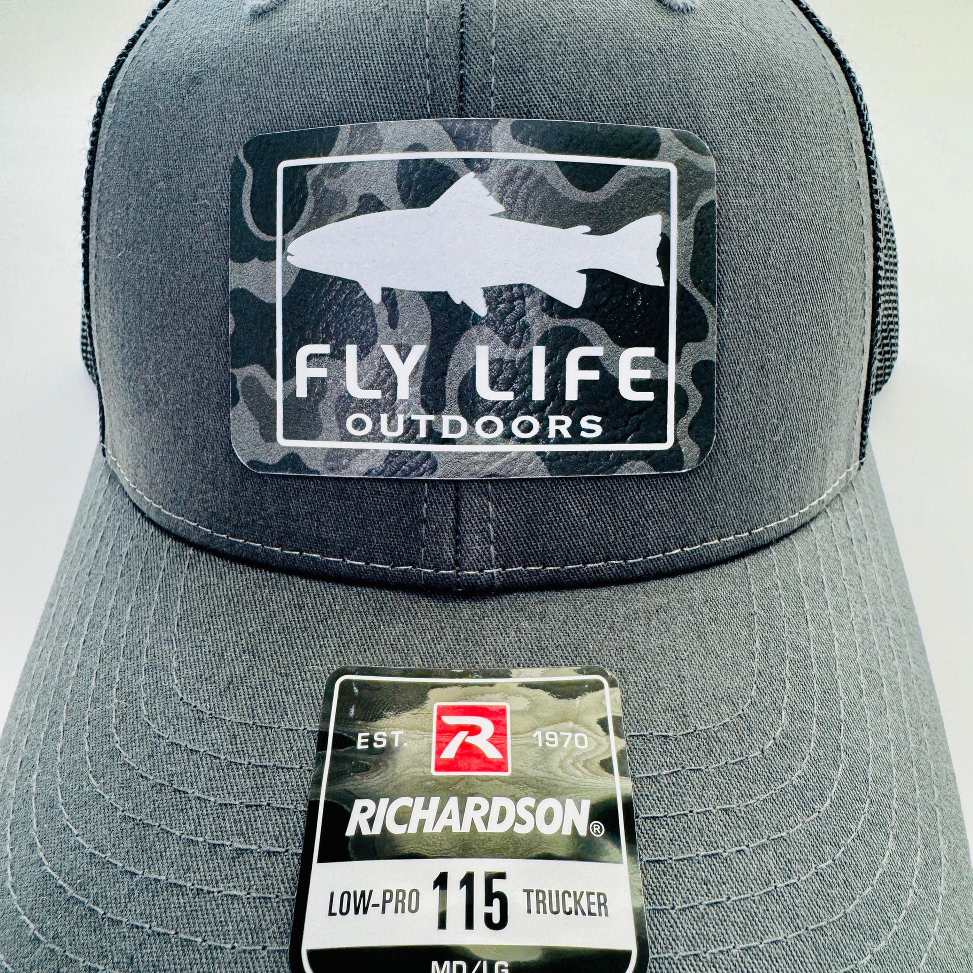 Close up view of The FLO 115 Trucker in Charcoal with White Trout/Black Skies Camo patch | Charcoal/Black