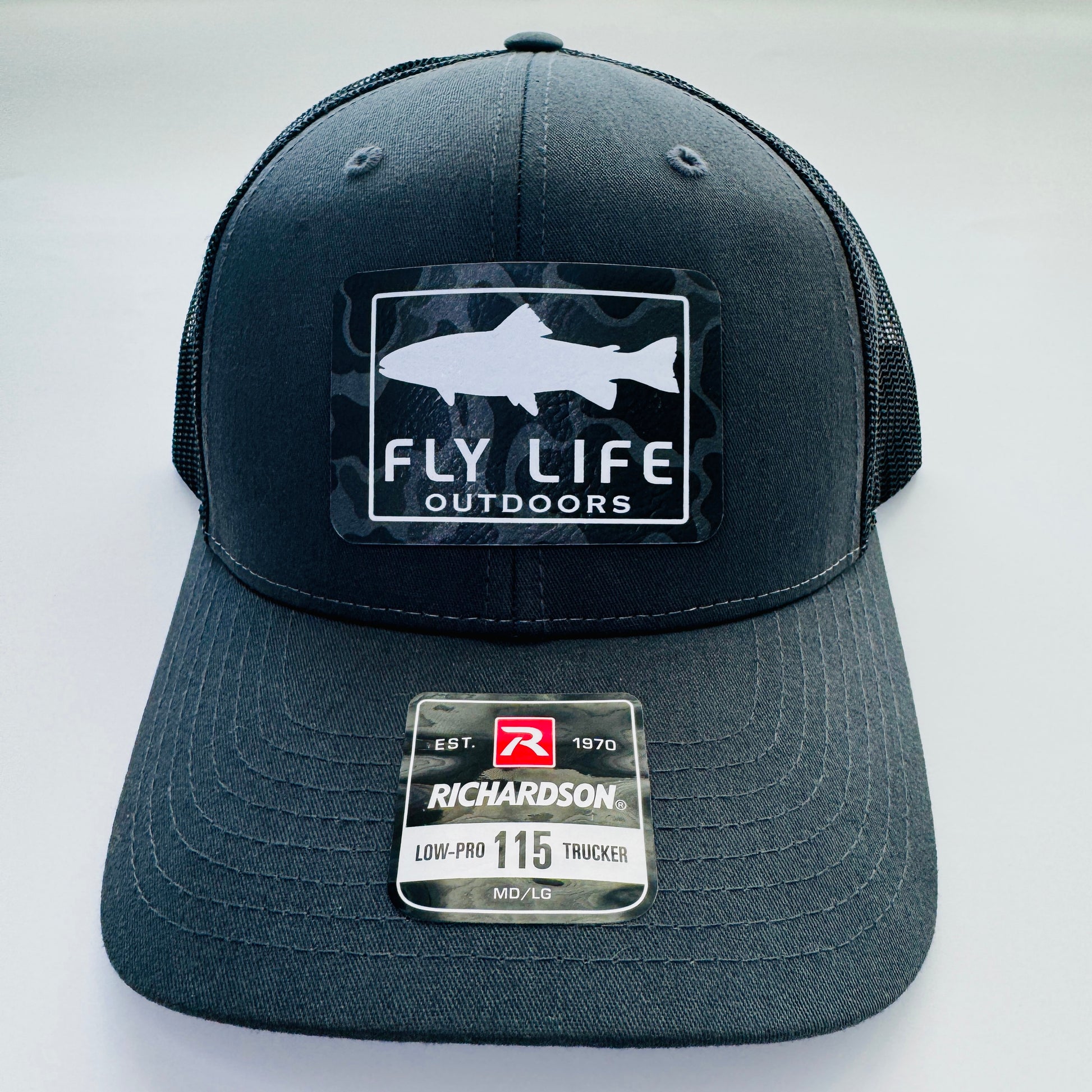 Front view of The FLO 115 Trucker in Charcoal with White Trout/Black Skies Camo patch | Charcoal/Black