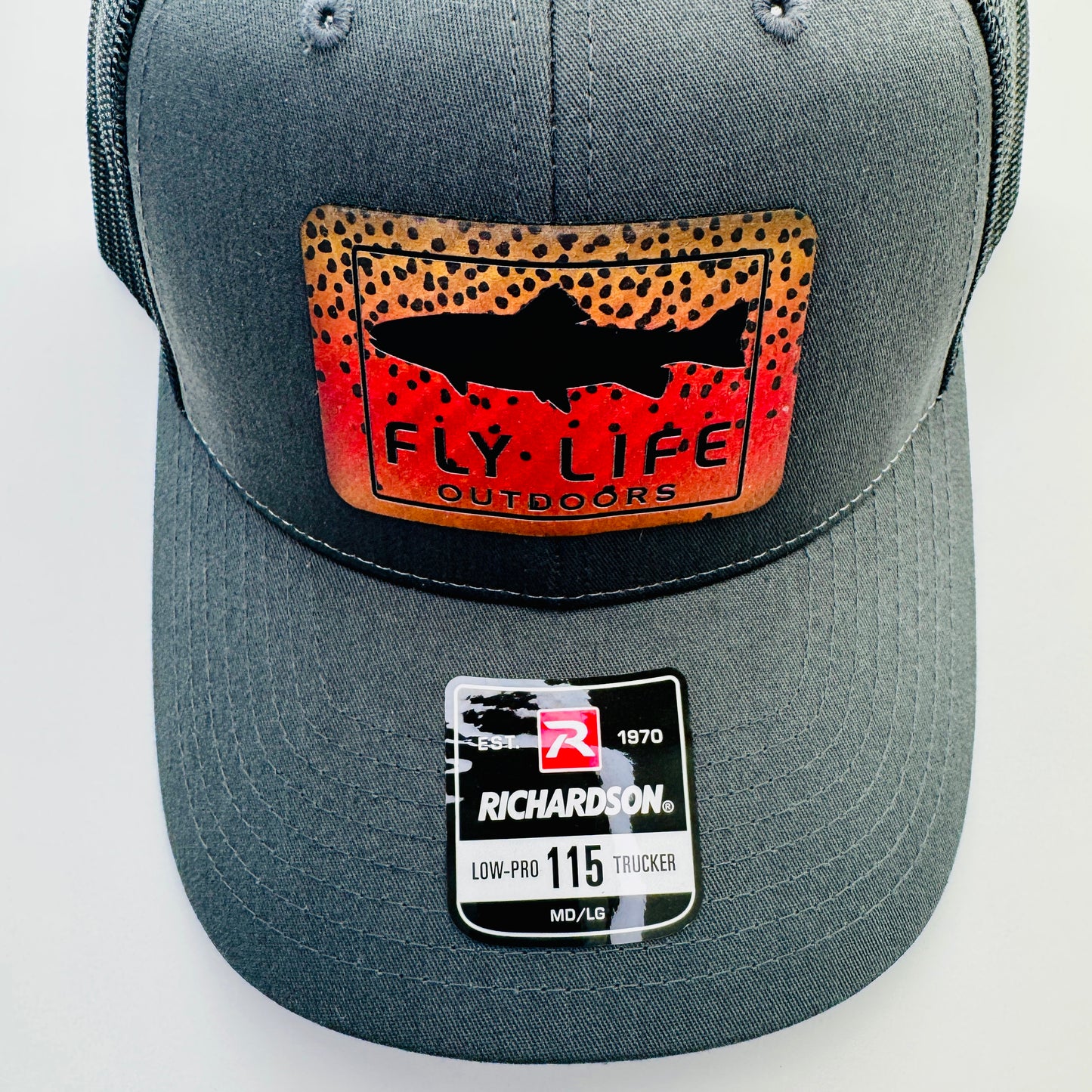 Close up view of the patch and bill of The FLO 115 Trucker in Charcoal with Black Trout/Cutthroat patch | Charcoal/Black