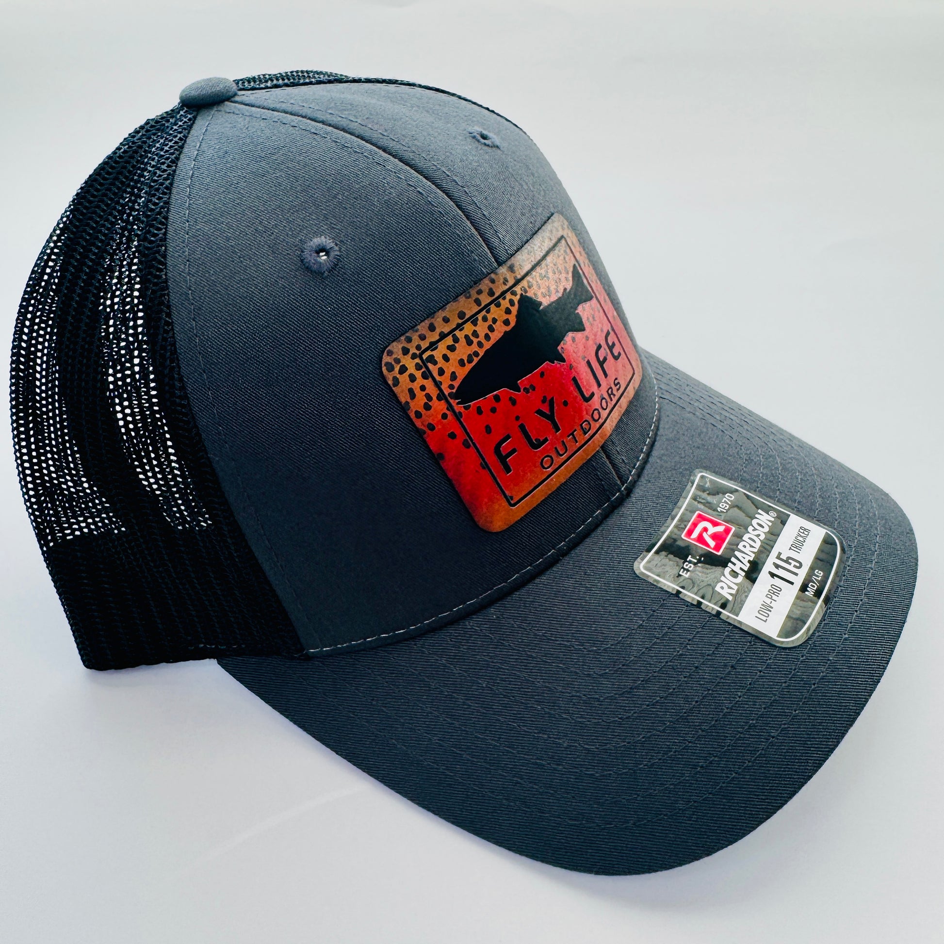 Left angle view of The FLO 115 Trucker in Charcoal with Black Trout/Cutthroat patch | Charcoal/Black