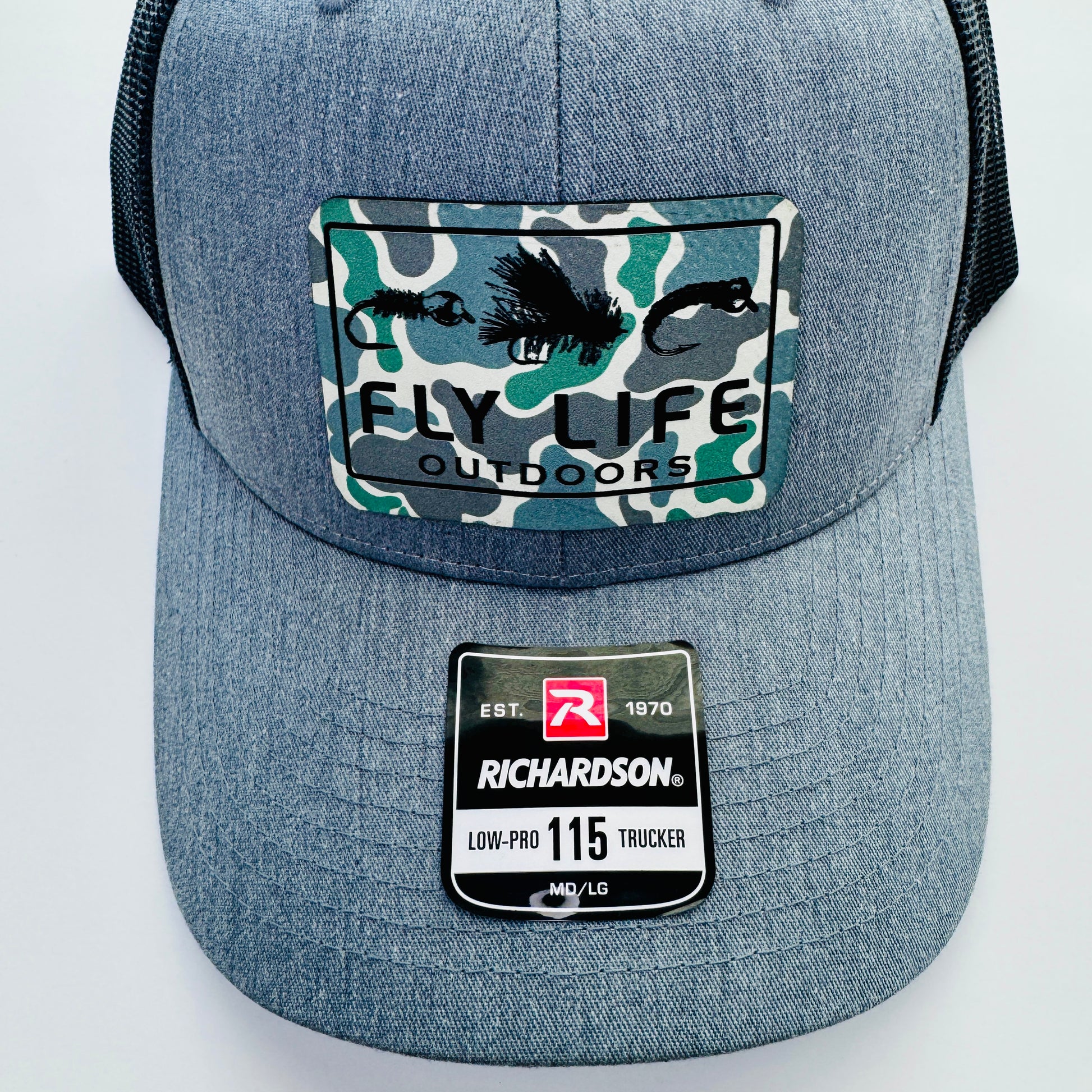 Close up view of the patch and bill of The FLO 115 Trucker in Heather with Black Tri-Fly/Low Tide Camo patch | Heather Grey/Black