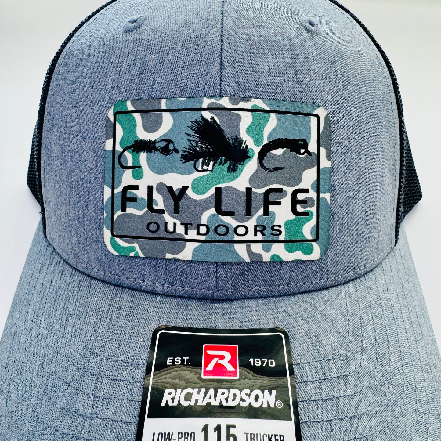 Close up view of The FLO 115 Trucker in Heather with Black Tri-Fly/Low Tide Camo patch | Heather Grey/Black