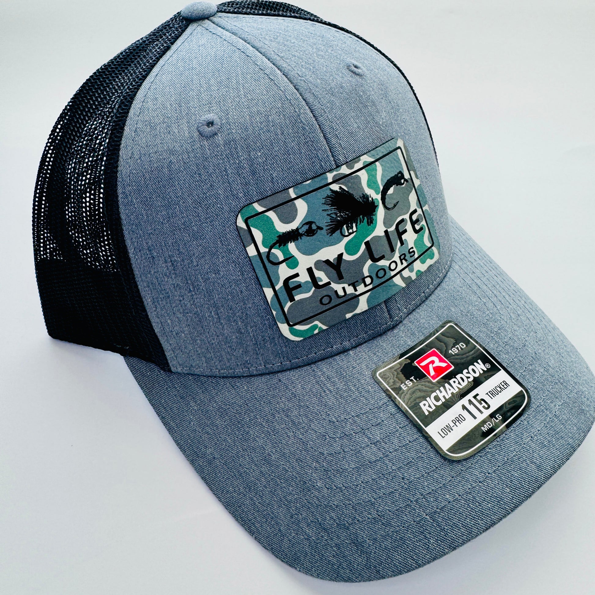 Left angle view of The FLO 115 Trucker in Heather with Black Tri-Fly/Low Tide Camo patch | Heather Grey/Black