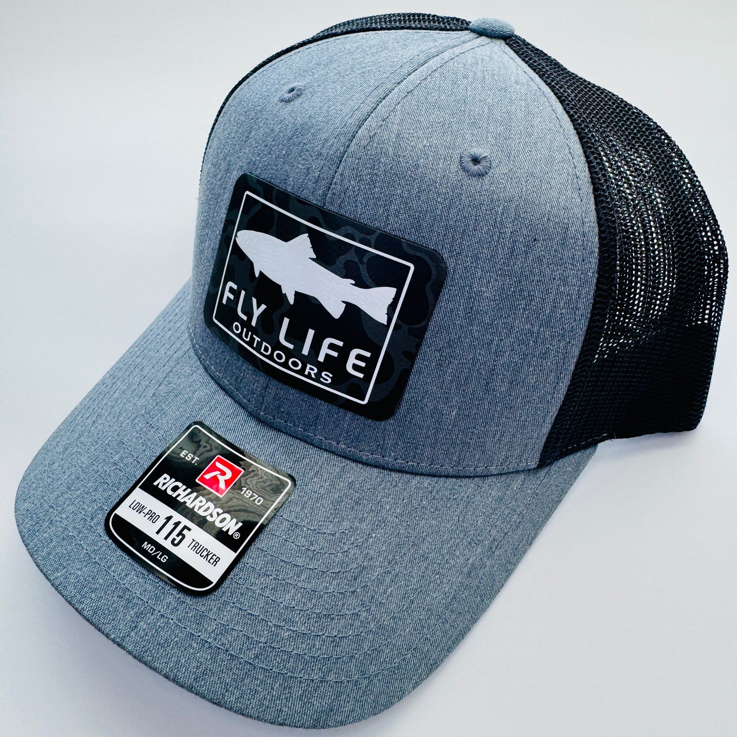 Right angle view of The FLO 115 Trucker in Heather Grey with White Trout/Black Skies Camo patch | Heather Grey/Black