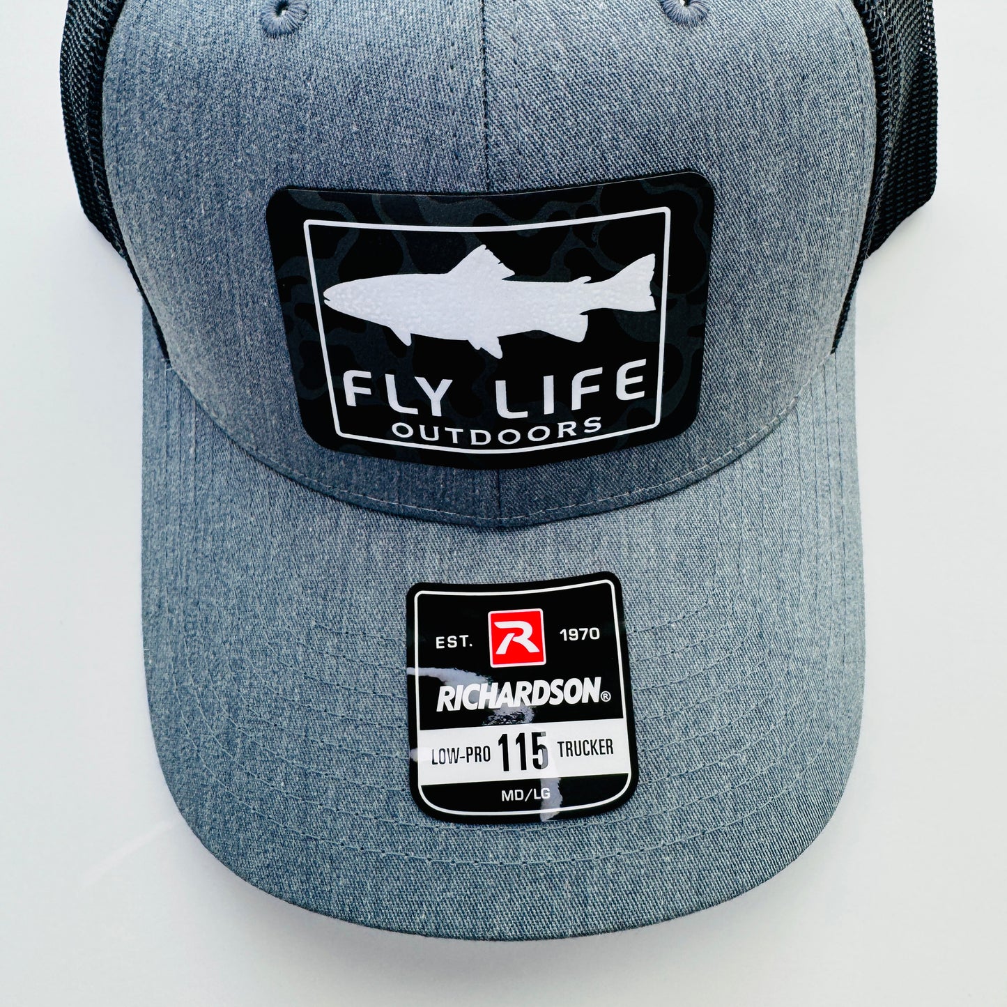 Top view of patch and hat of The FLO 115 Trucker in Heather Grey with White Trout/Black Skies Camo patch | Heather Grey/Black