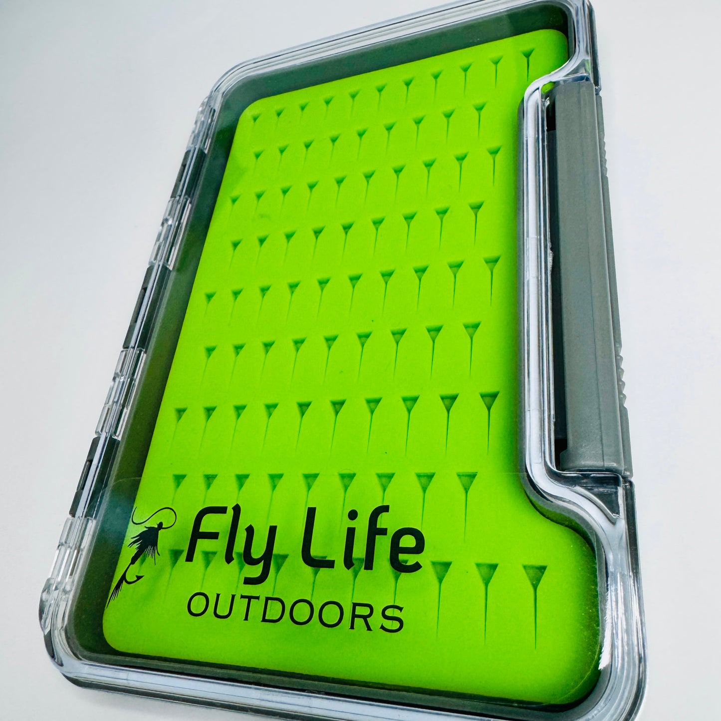 A detailed macro view of the precision-cut, high-grip green silicone insert inside The Guardian Fly Box.