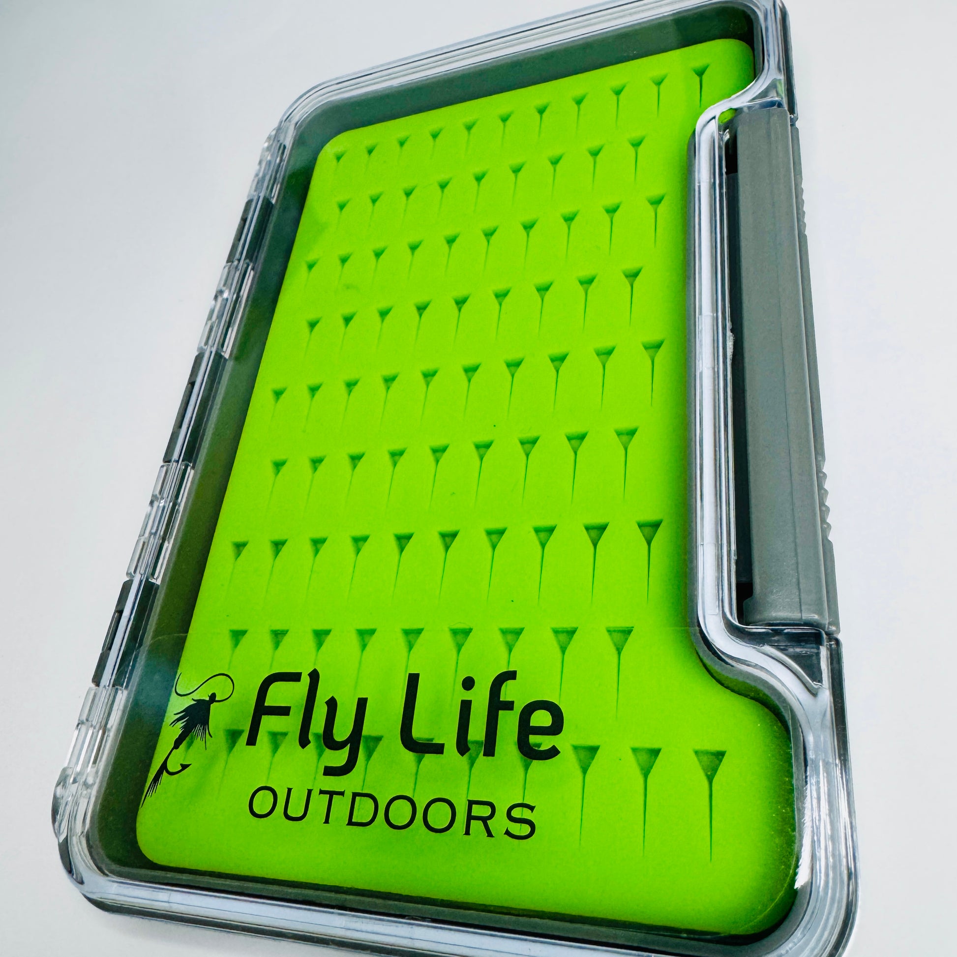 A detailed macro view of the precision-cut, high-grip green silicone insert inside The Guardian Fly Box.